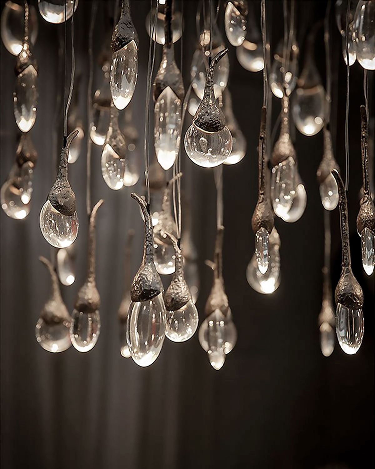 Cluster of teardrop glass pendant lights with textured metal caps